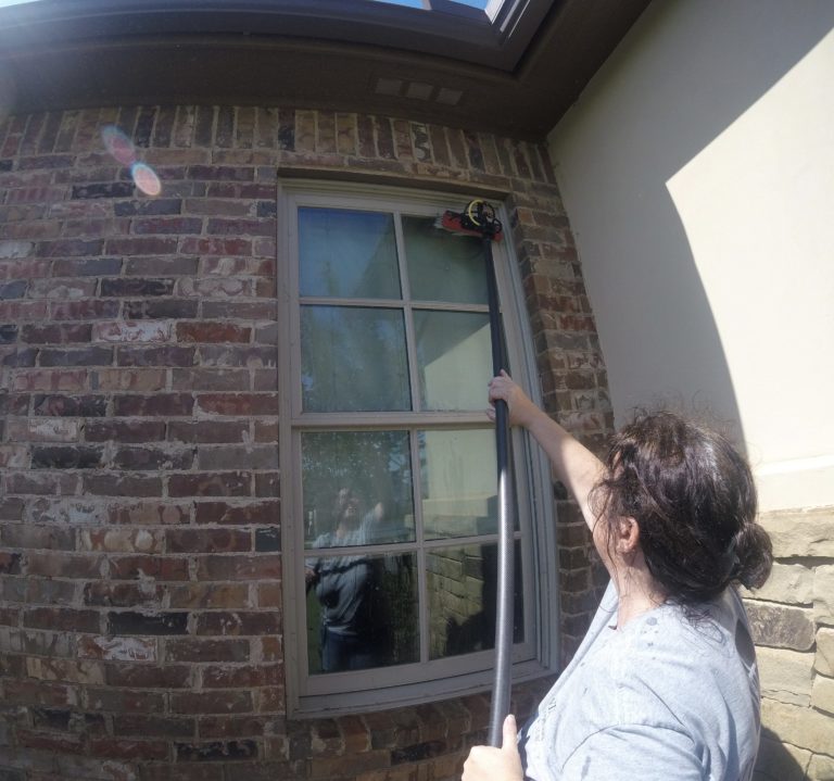 Woman cleaning residential window